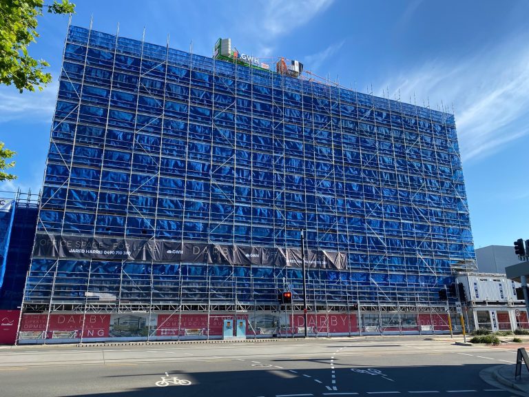 Advertising banners for "Darby" are attached to the scaffolding.